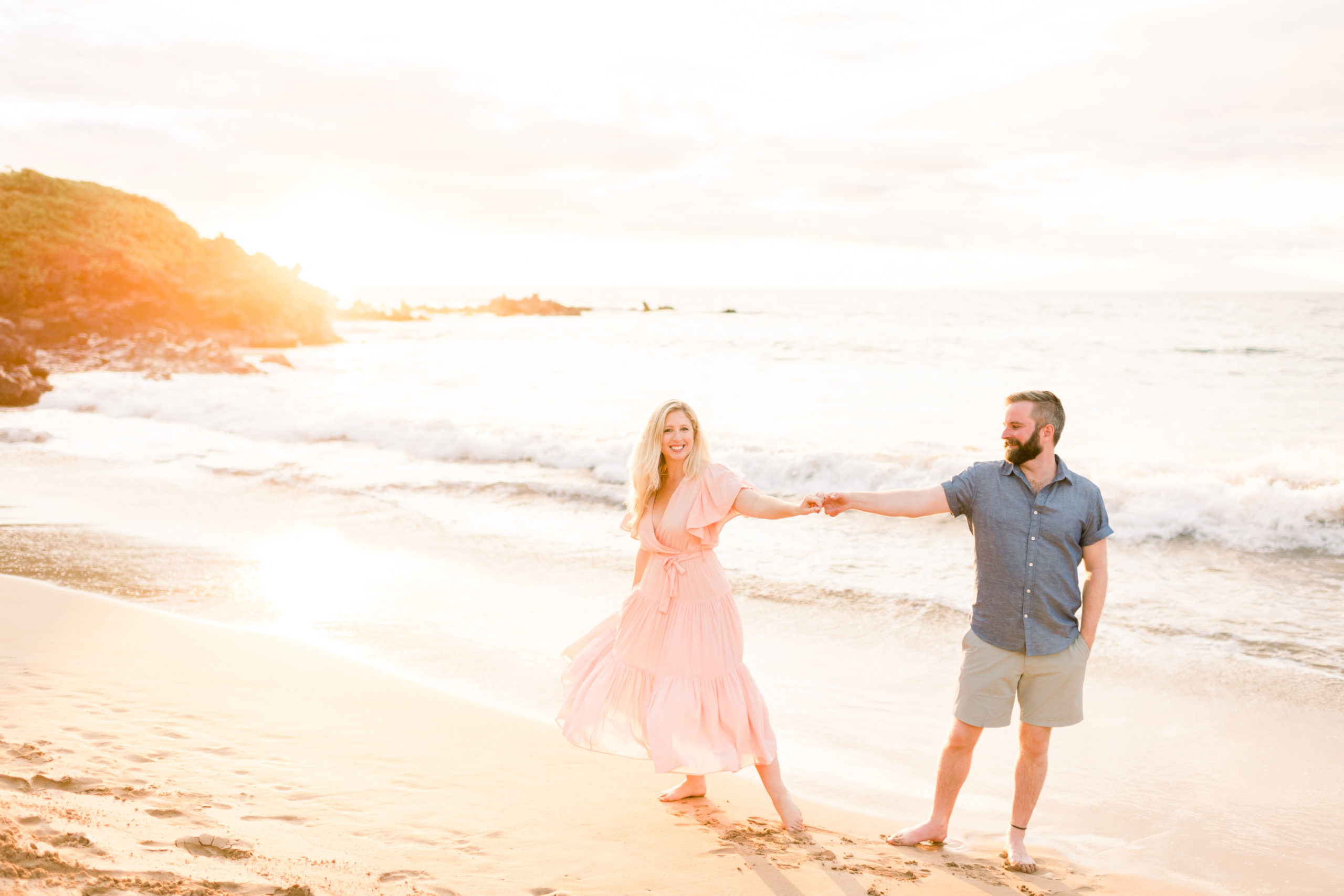Man and Woman holding hands posing for their Honeymoon Sunset Beach Portraits