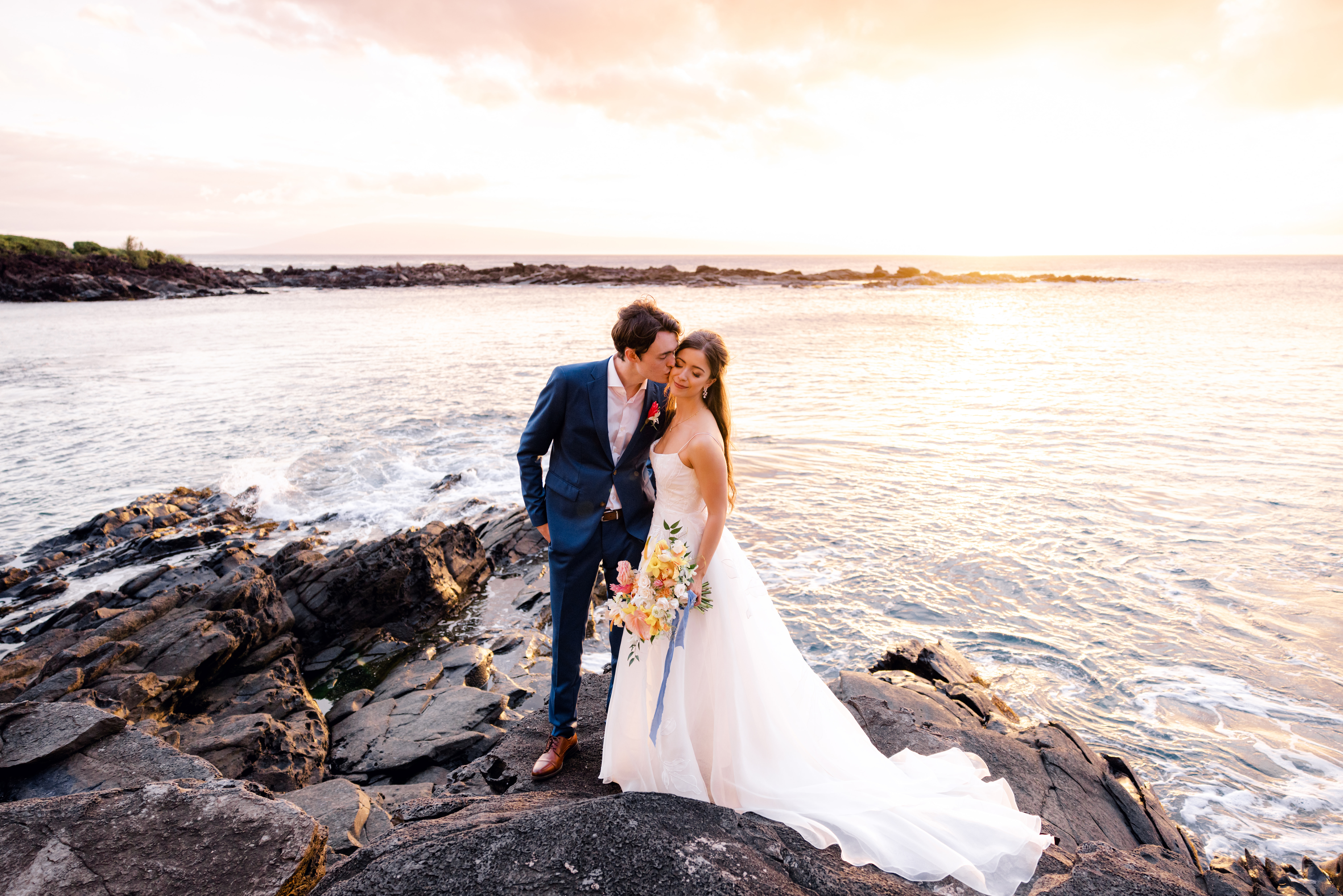 Intimate portraits of Groom kissing bride during sunset