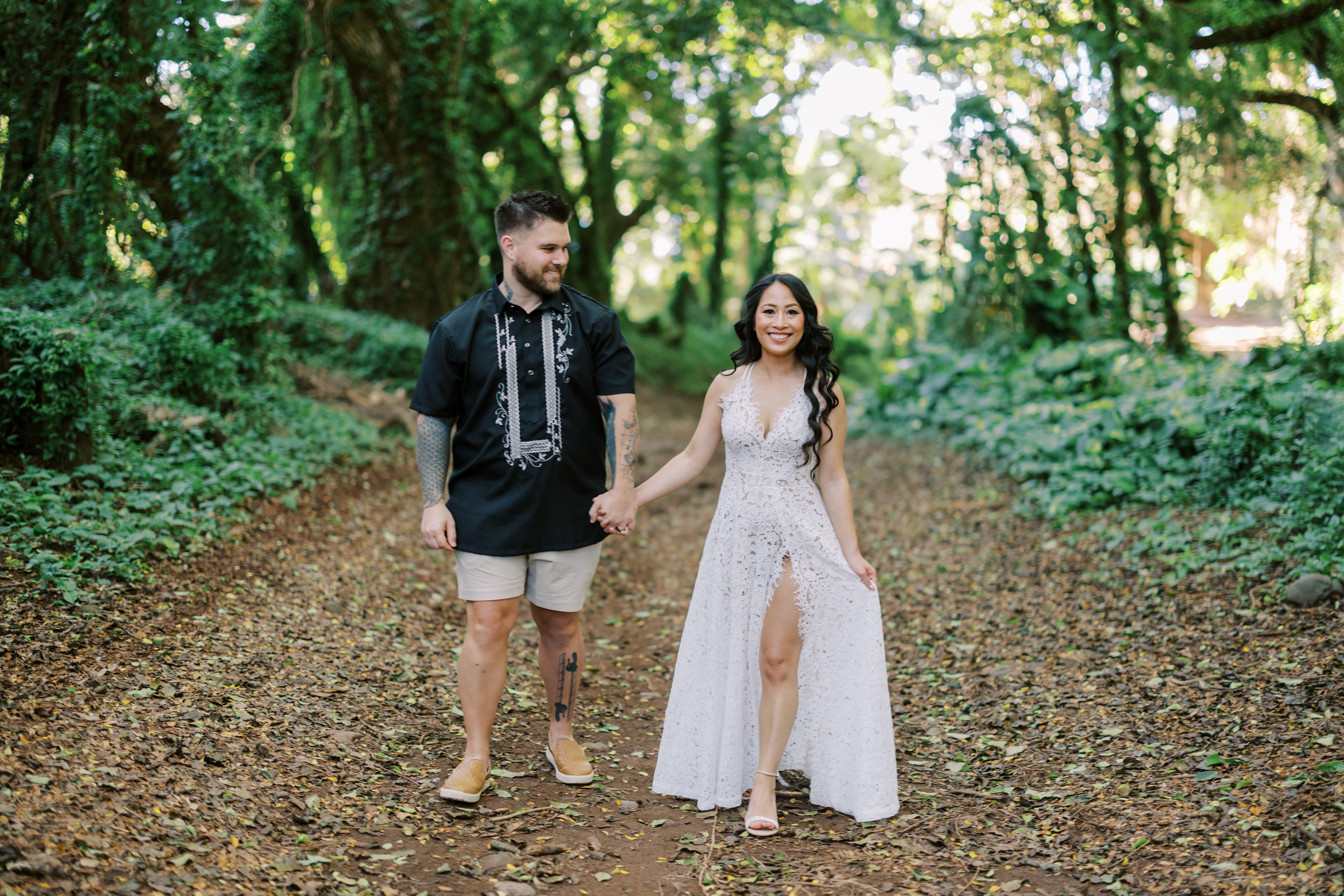 Couple holding hands while standing in a Maui forest celebrating anniversary